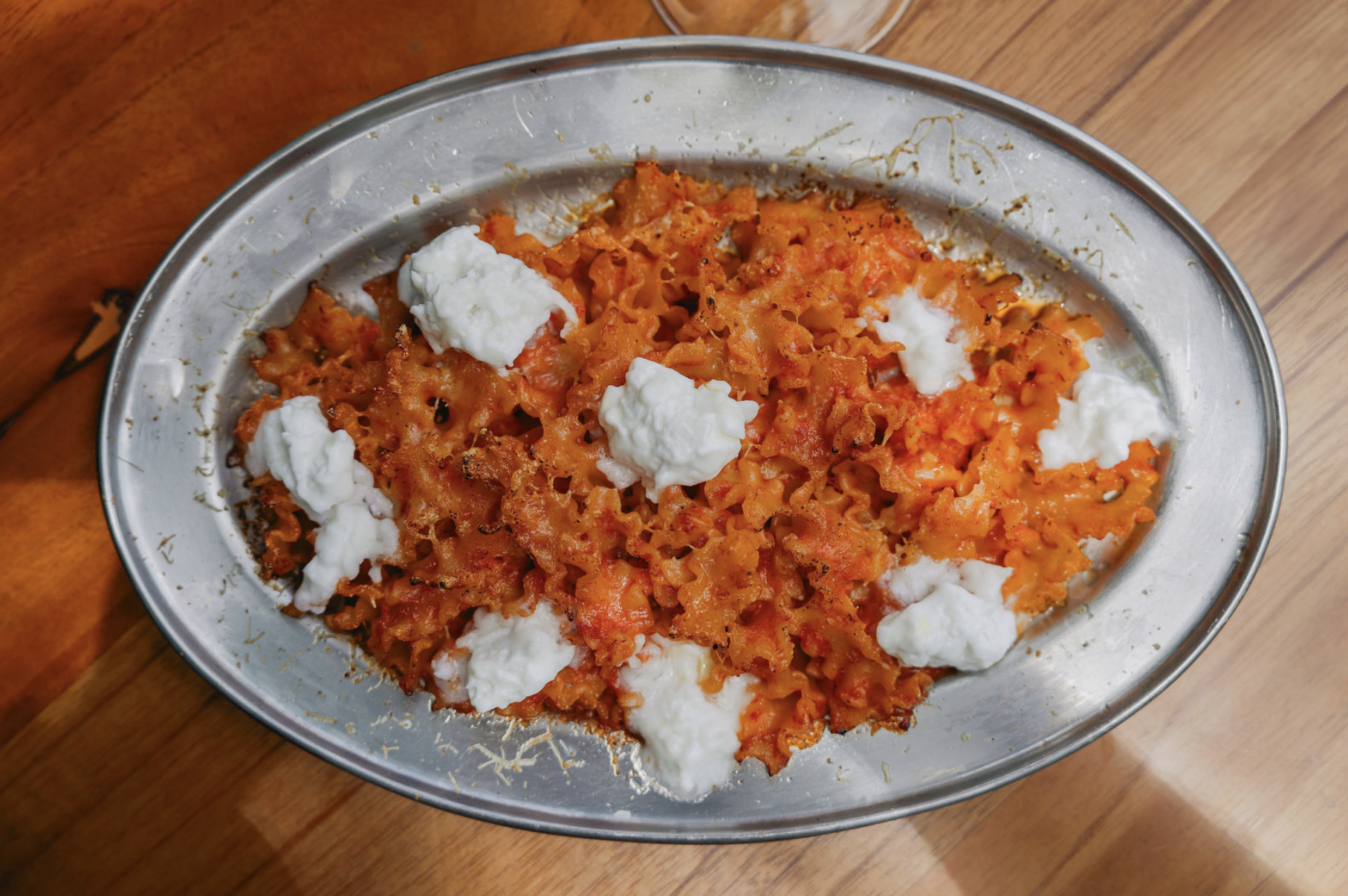 Plato de pasta corta en salsa pomodoro y crema dulce con 'nduja y stracciatella
